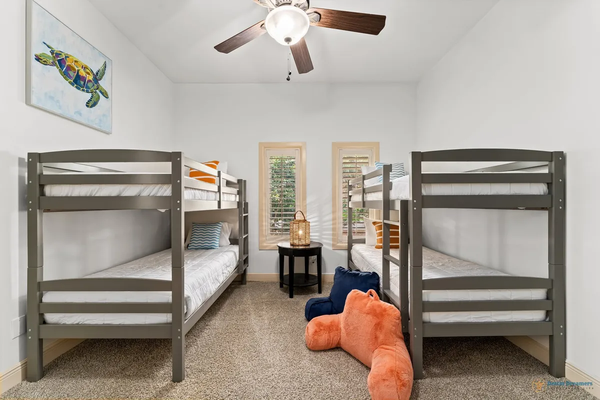 A cheerful bunk room with colorful turtle artwork, striped pillows, and playful decor. The space is designed for fun, relaxation, and shared experiences, perfect for families or groups recharging after outdoor excursions.