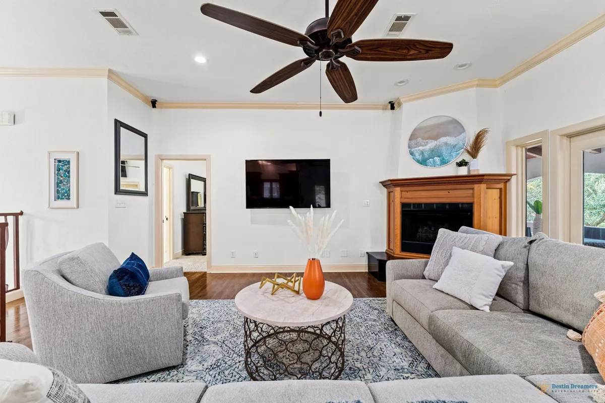 A cozy living room with a comfortable sofa, coffee table, TV, and a fireplace, radiating warmth and comfort. The space is ideal for relaxing after a day of biking, swimming, or exploring local attractions.